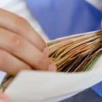 Person handling financial documents for rental property management.
