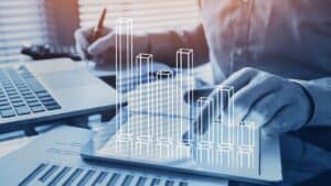 Person analyzing rental data with digital bar graph overlay.