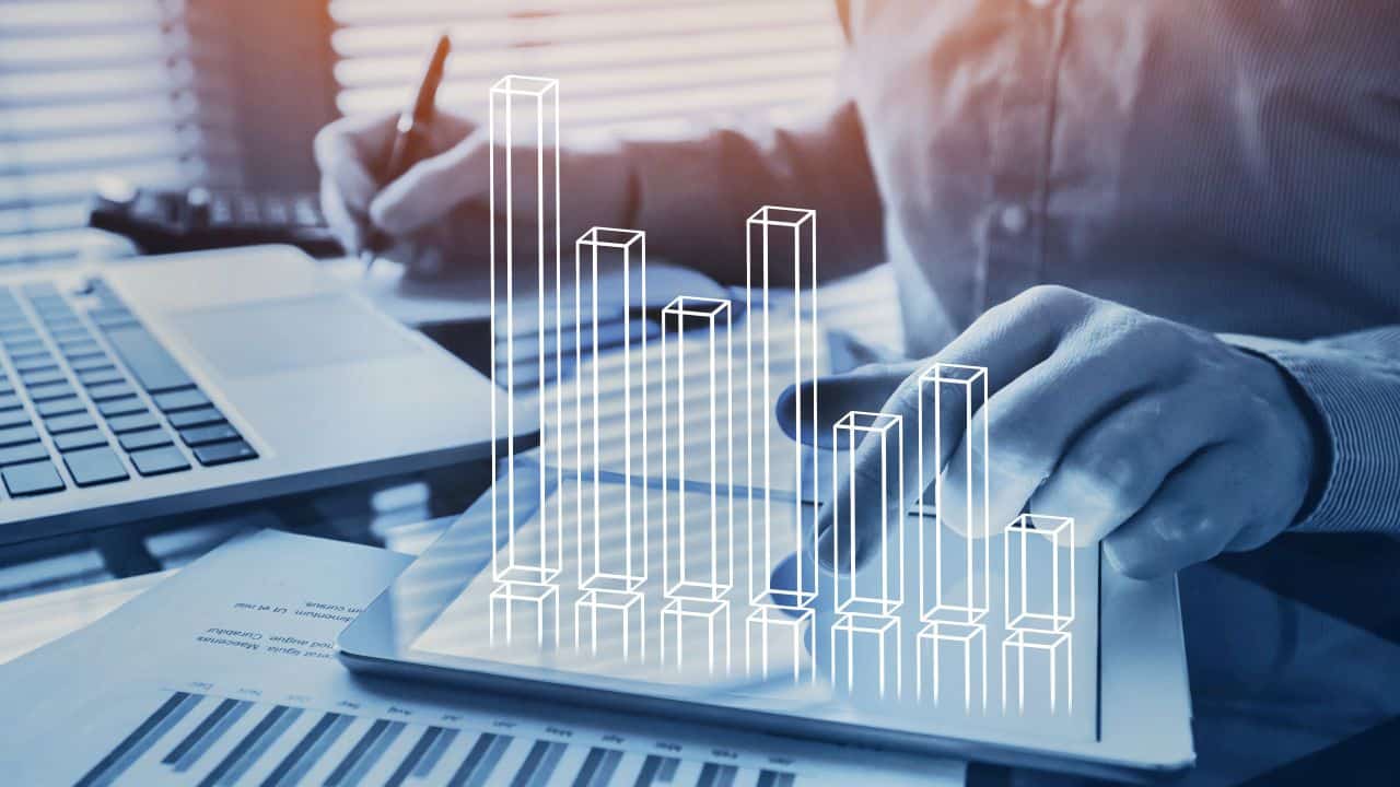Person analyzing rental data with digital bar graph overlay.