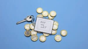 Key and coins with a 'Buy to Let' sign for property investment.