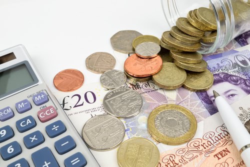 Coins and banknotes with calculator for landlord financial planning.