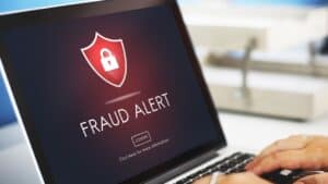Laptop screen showing fraud alert with shield and lock icon for landlord security.