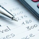 Close-up of a pen, calculator, and financial notes for landlords.