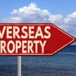 Overseas property sign pointing to international real estate opportunities.