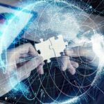Hands assembling a puzzle over a digital globe with data charts and network lines.